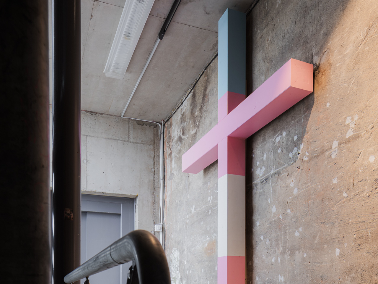 Art installation with wooden cross in pink, white and blue